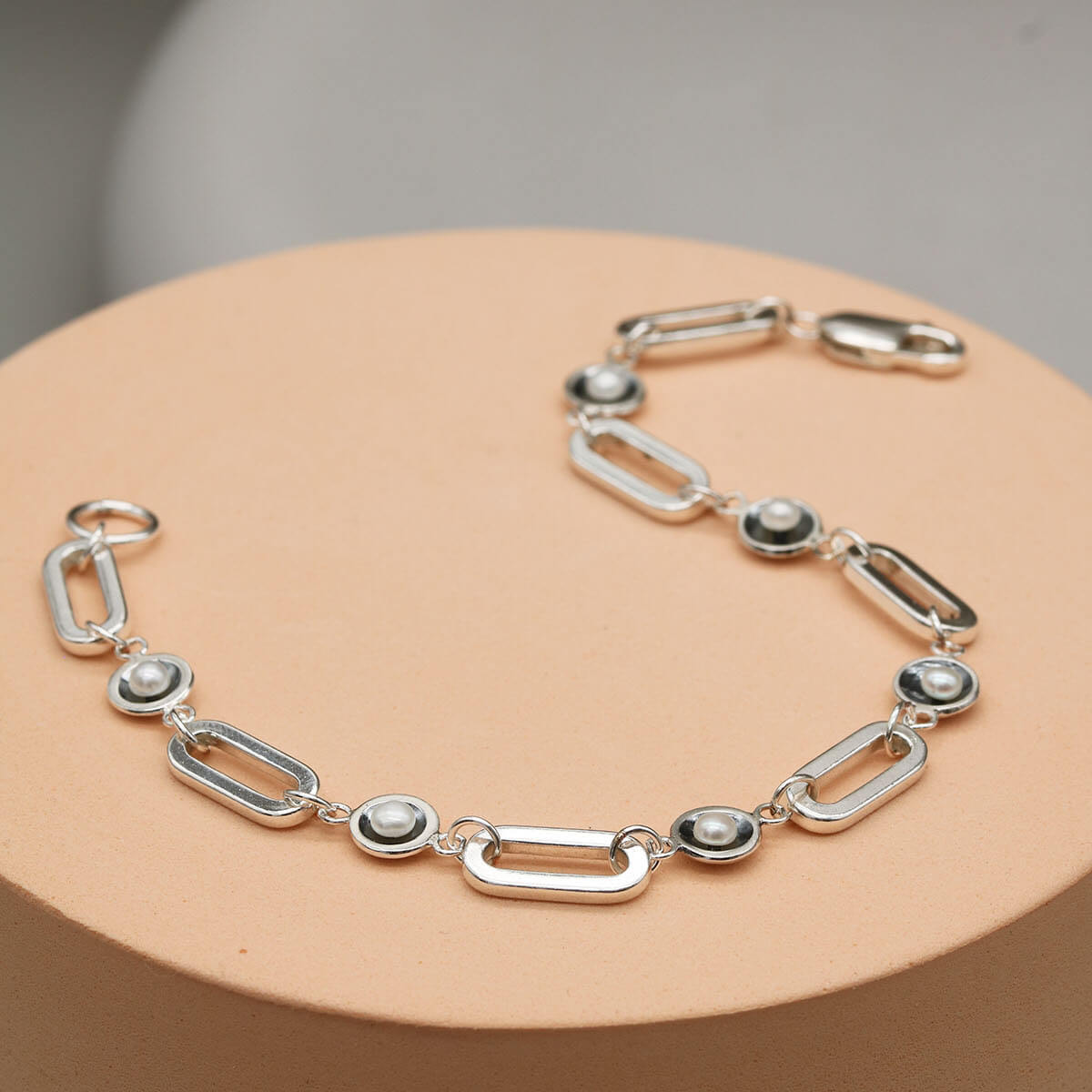 Handmade black pearl bracelet showcasing five genuine freshwater pearls spaced between sterling silver rectangular links.
