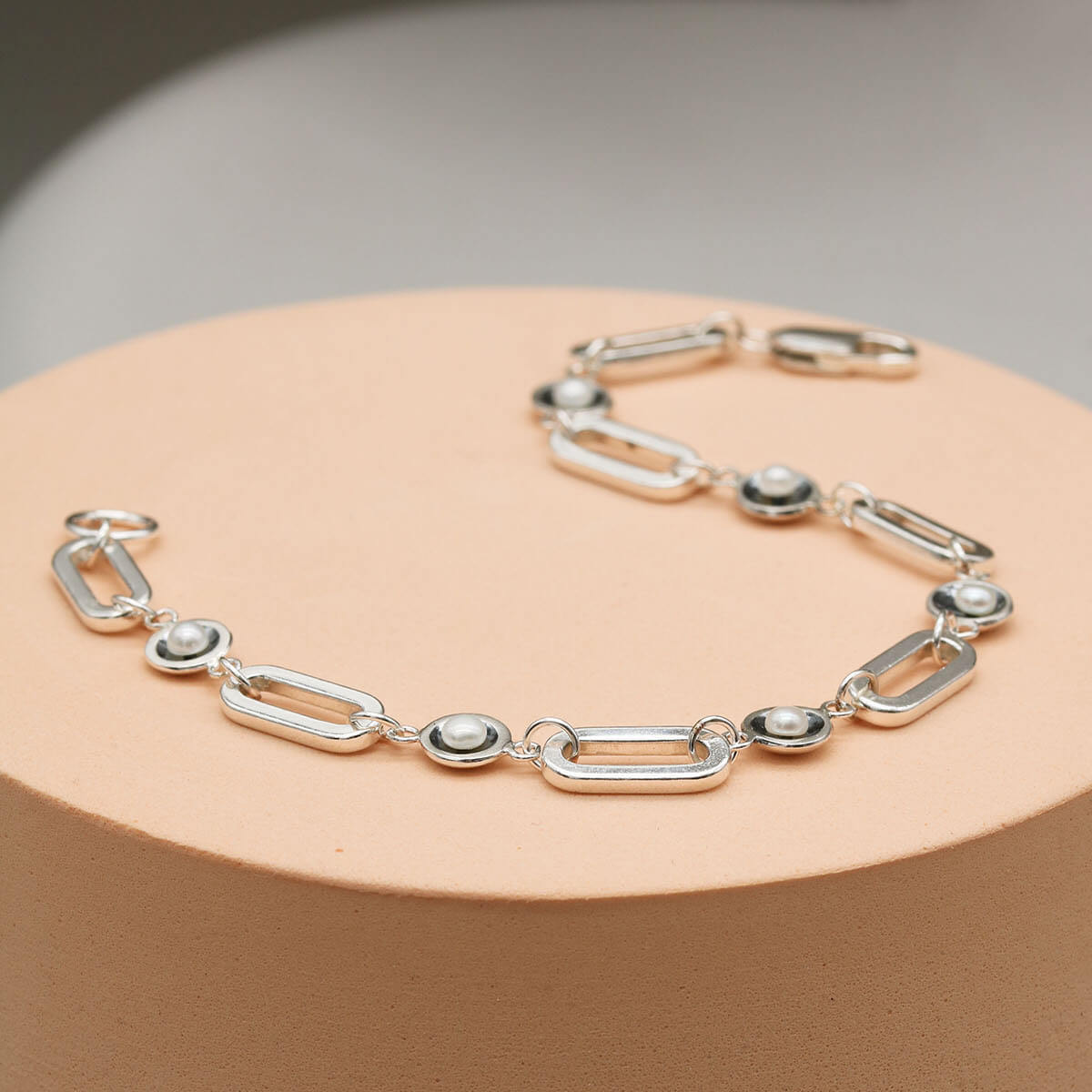 Close up of a black pearl chain bracelet highlighting the contrast between oxidised sterling silver settings and luminous freshwater pearls.