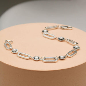 Close up of a black pearl chain bracelet highlighting the contrast between oxidised sterling silver settings and luminous freshwater pearls.