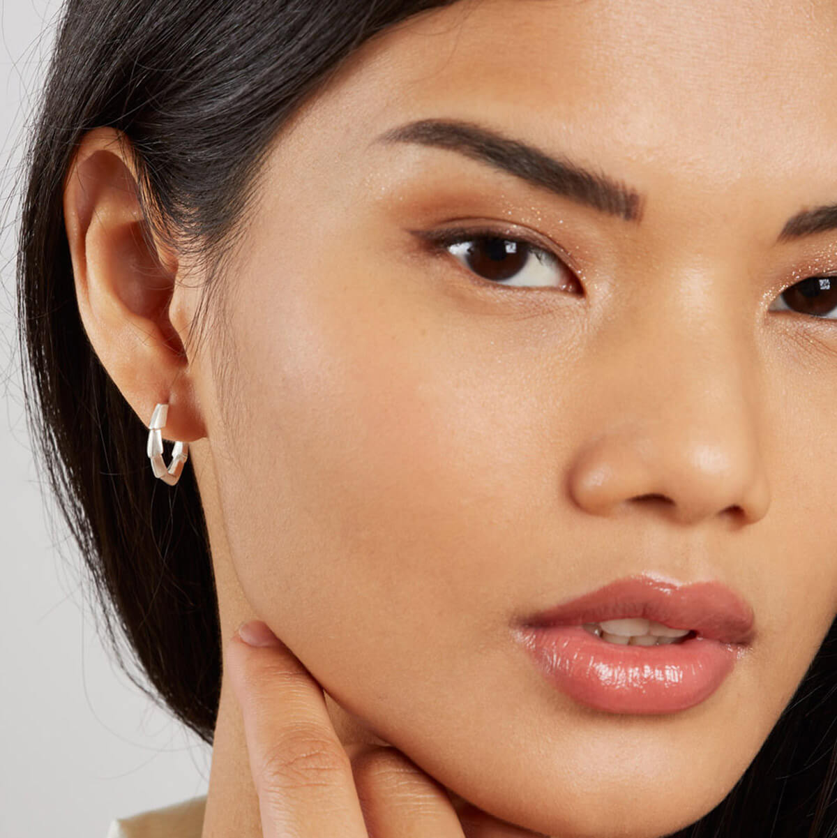 Woman wearing sterling silver half hoop earrings, showing the Art Deco-inspired geometric design and everyday scale