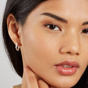 Woman wearing sterling silver half hoop earrings, showing the Art Deco-inspired geometric design and everyday scale
