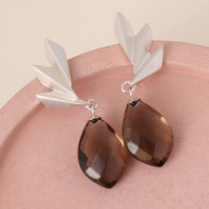 Art deco statement earrings displayed on a soft pink dish with teardrop smoky quartz stones; perfect anniversary or birthday gift.