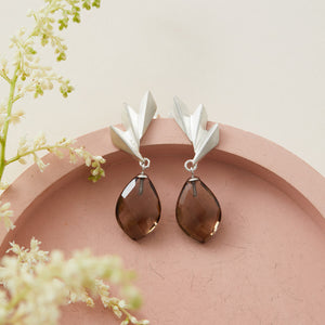 Close-up of smoky quartz earrings highlighting the sculptural fan motif and gemstone sparkle; elegant art deco statement earrings for special occasions.