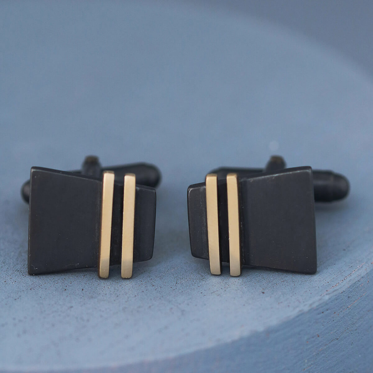 Detailed image of Black and Gold cufflinks on deep blue background showing oxidised silver texture, perfect special cufflinks for elegant gifting occasions.