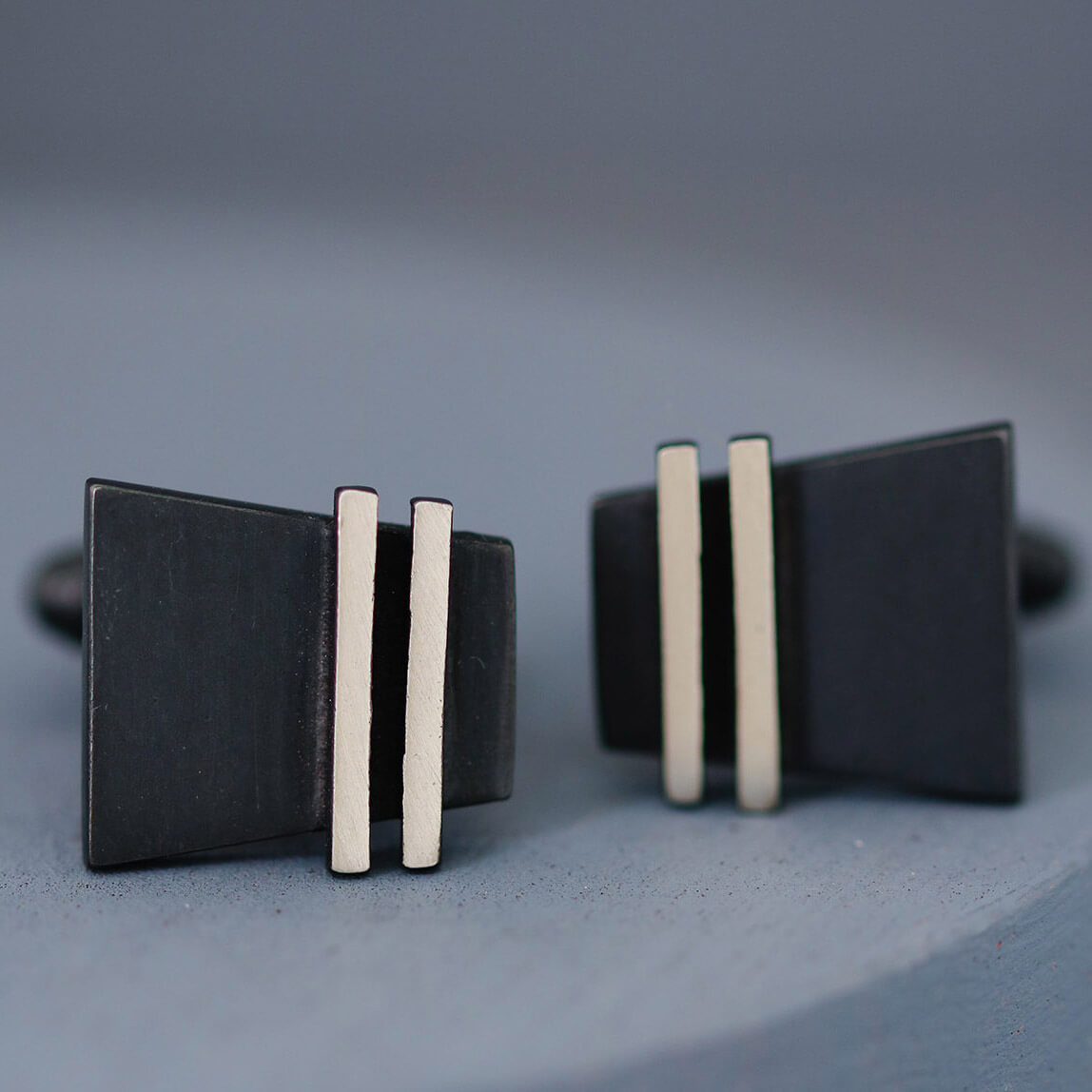 Pair of black cufflinks photographed face-on to show contrast between matte black surface and shiny silver border. Perfect gift for husband or groom.