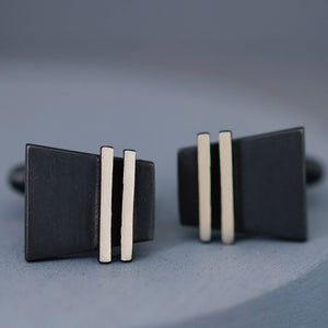 Pair of black cufflinks photographed face-on to show contrast between matte black surface and shiny silver border. Perfect gift for husband or groom.