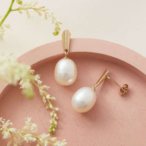 Close-up of 9ct gold pearl earrings on pink dish highlighting Art Deco gold setting – 9ct gold pearl earrings for brides