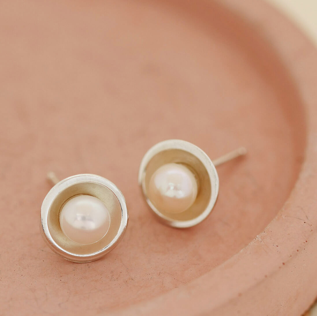 Delicate real pearl stud earrings styled on a pink dish, perfect Pearl Earrings for women and thoughtful gift-ready studs.