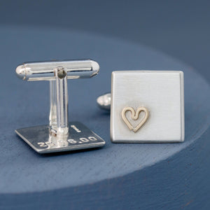 Close-up of hand-stamped text on the back of one cufflink, revealing the personalised message — Custom cufflinks for groom.
