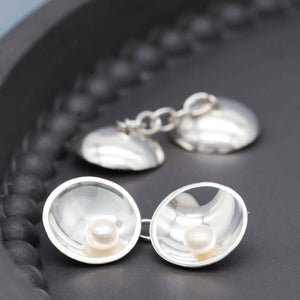 Close up of handmade double-sided pearl cufflinks showing polished sterling silver and natural freshwater pearls.