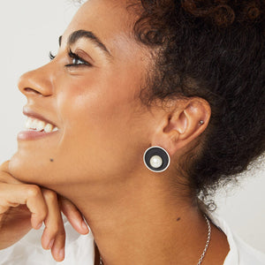 Model wearing black pearl stud earrings showing size and fit