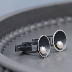 Art Deco inspired black pearl cufflinks featuring geometric sterling silver details and natural freshwater pearls.