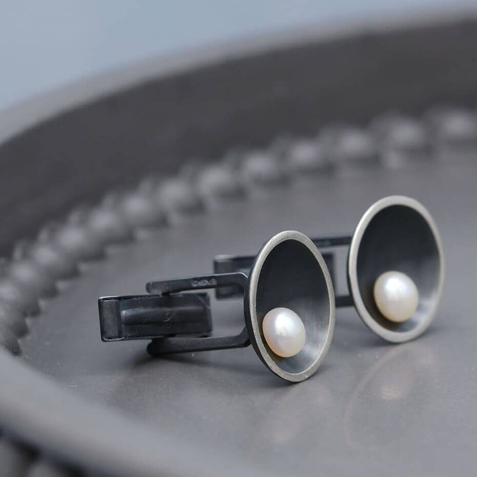 Art Deco inspired black pearl cufflinks featuring geometric sterling silver details and natural freshwater pearls.