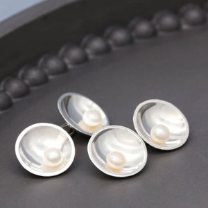 Handmade freshwater pearl cufflinks connected by a sterling silver chain, designed to be viewed from every angle.