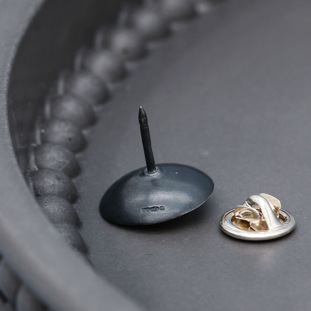Black pearl lapel pin handcrafted in sterling silver with a polished freshwater pearl centre.