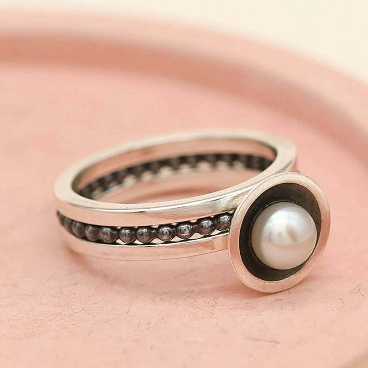 Side view of a stacking ring set with oxidised silver pearl ring
