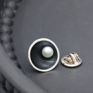 Close up of handmade black pearl tie pin showing the contrast between oxidised sterling silver and a genuine freshwater pearl.