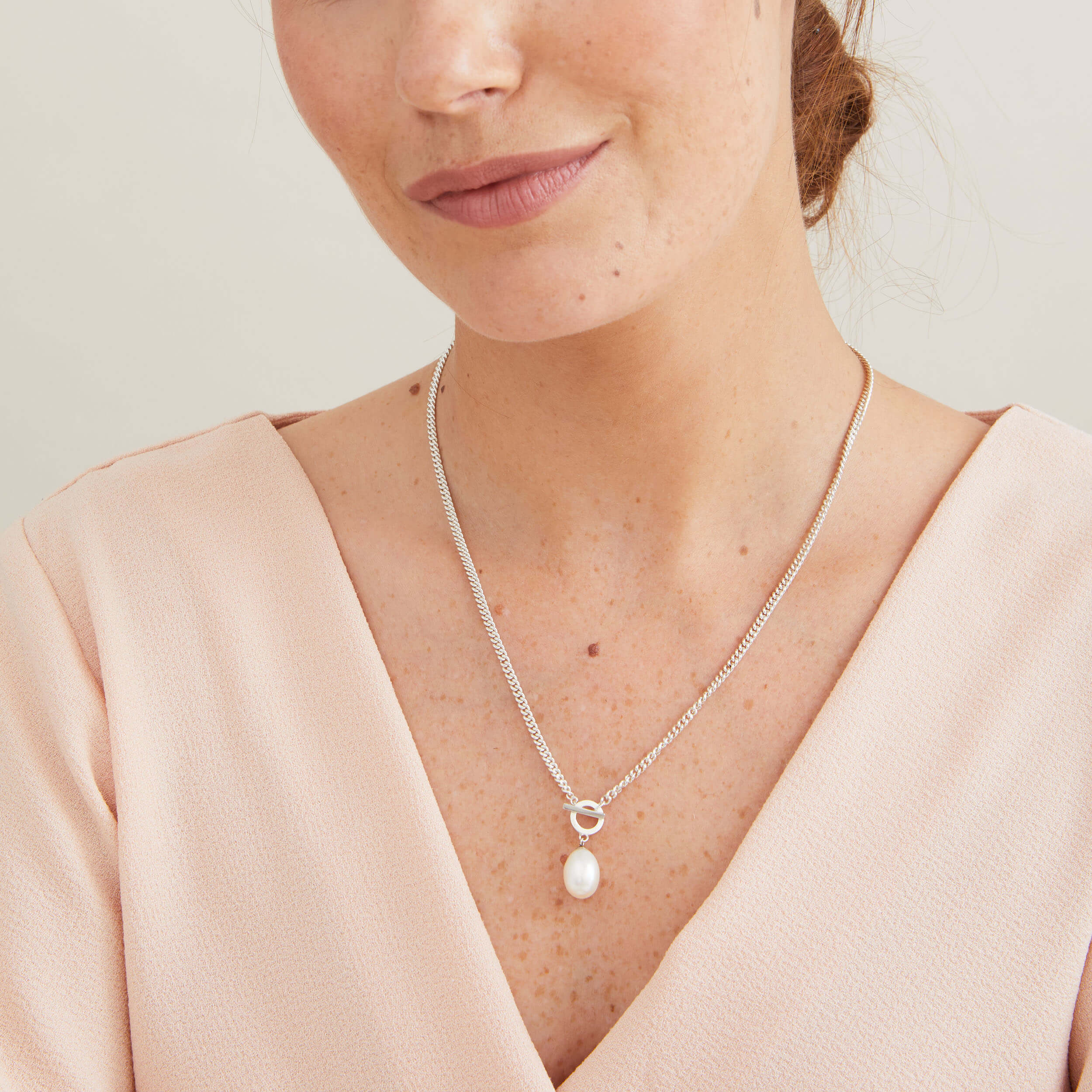 Sterling silver toggle pearl necklace worn with a white blouse, showcasing the bold curb chain and large freshwater pearl.