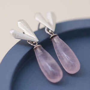 Sterling silver heart dangle earrings with rose quartz gemstone, delicate Pink heart earrings presented on a blue dish