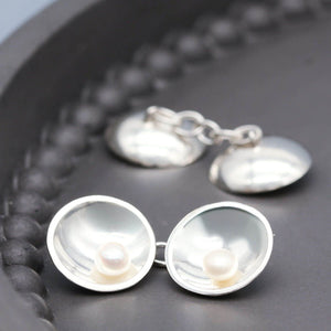 Sterling silver double-sided pearl cufflinks featuring freshwater pearls on both sides and a chain connection.
