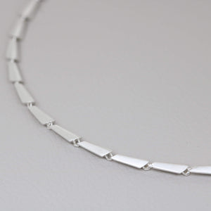 Art Deco silver necklace showing the repeating geometric pattern of individually carved and cast sterling silver links