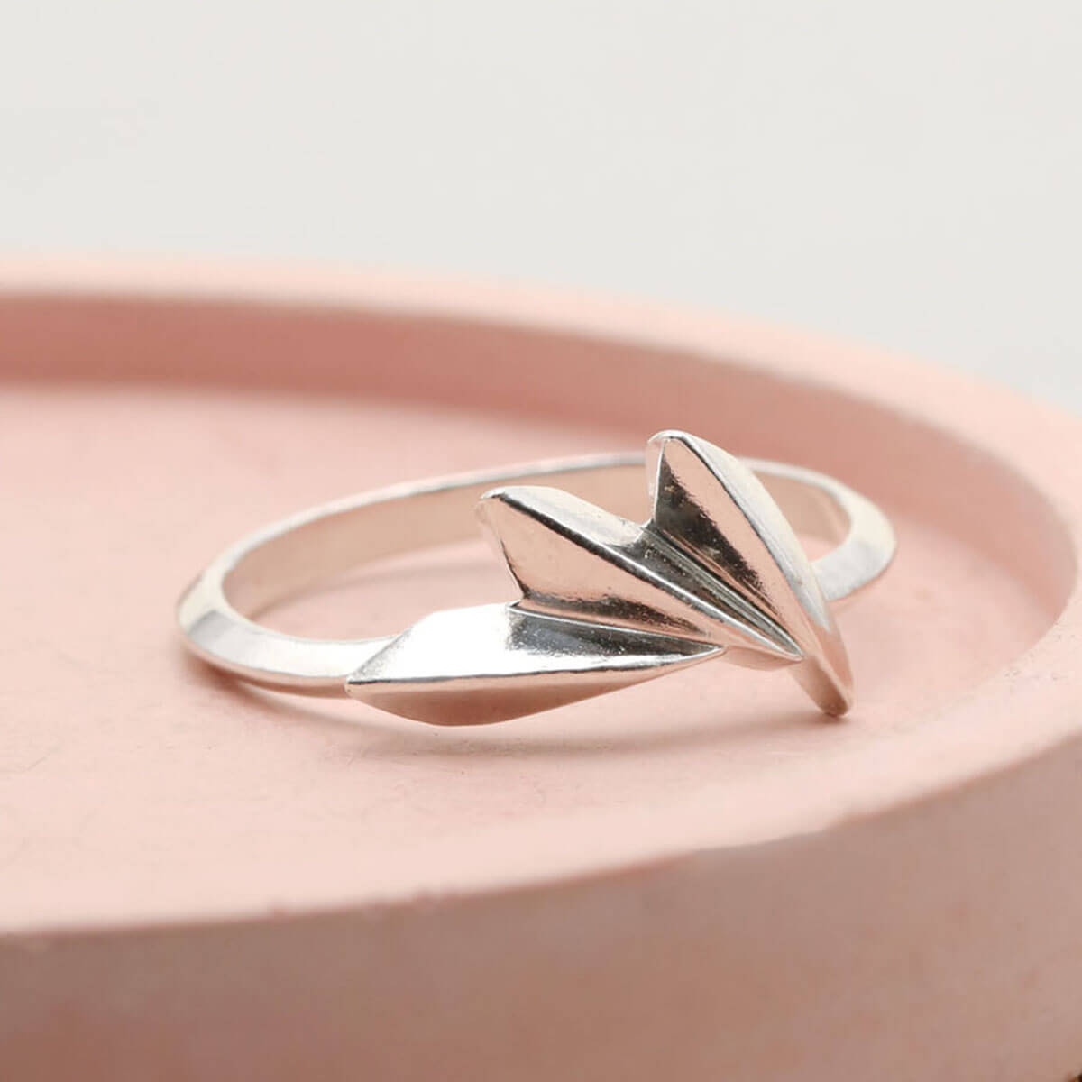 Art Deco fan ring in solid sterling silver displayed on a pink dish, a distinctive silver statement ring with geometric design
