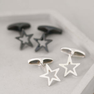 Side-by-side silver and black Star cufflinks displayed on a grey dish – minimalist and meaningful cufflinks for a graduation gift for son.