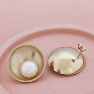 Large 9ct gold pearl earrings displayed on a pink ceramic dish