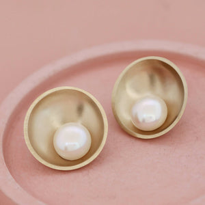 Close-up of polished 9ct gold pearl earrings with 10mm freshwater pearls
