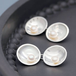Handmade sterling silver double-sided pearl cufflinks with genuine freshwater pearls displayed on a dark grey dish.