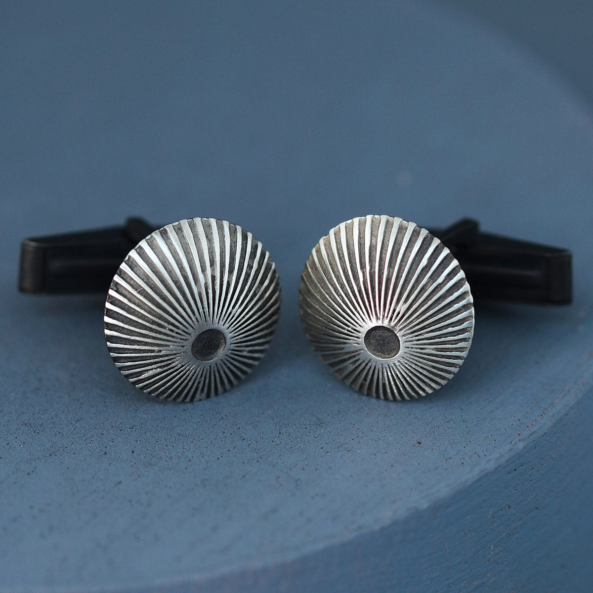 Close up of silver and black cufflinks showing oxidised sunburst detail, perfect mens luxury cufflinks gift for groom or anniversary.