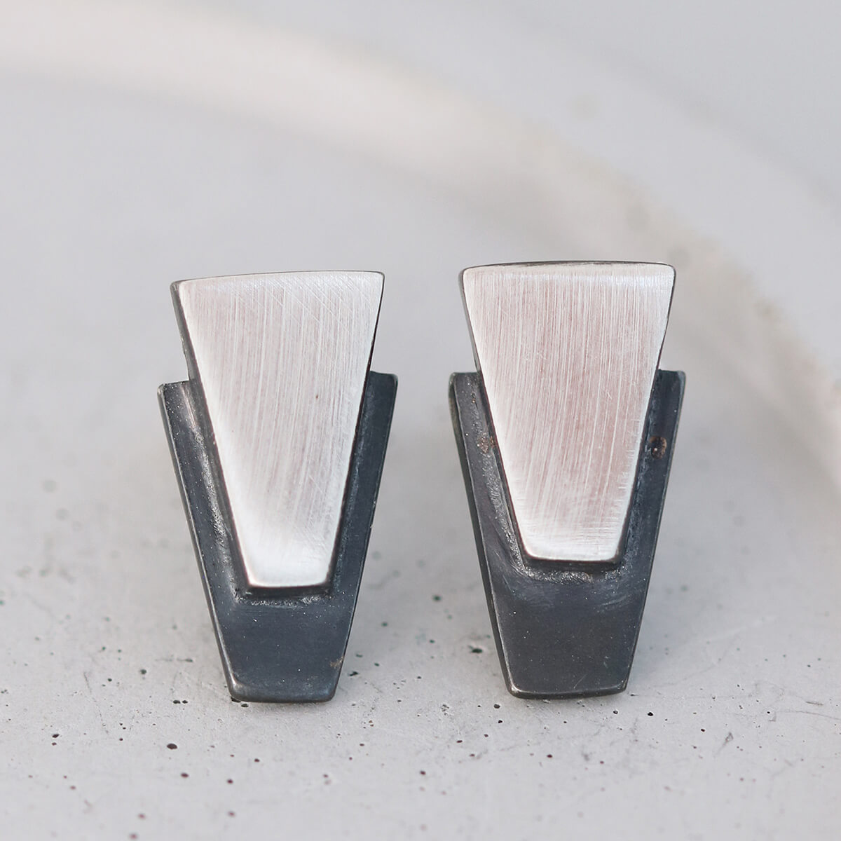 Contemporary black stud earrings for women displayed on grey dish, sterling silver finish ideal for everyday or wedding day gifts.