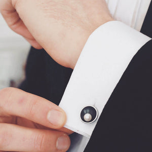 Black pearl cufflinks for men worn on a white dress shirt cuff, styled for formal occasions and weddings.