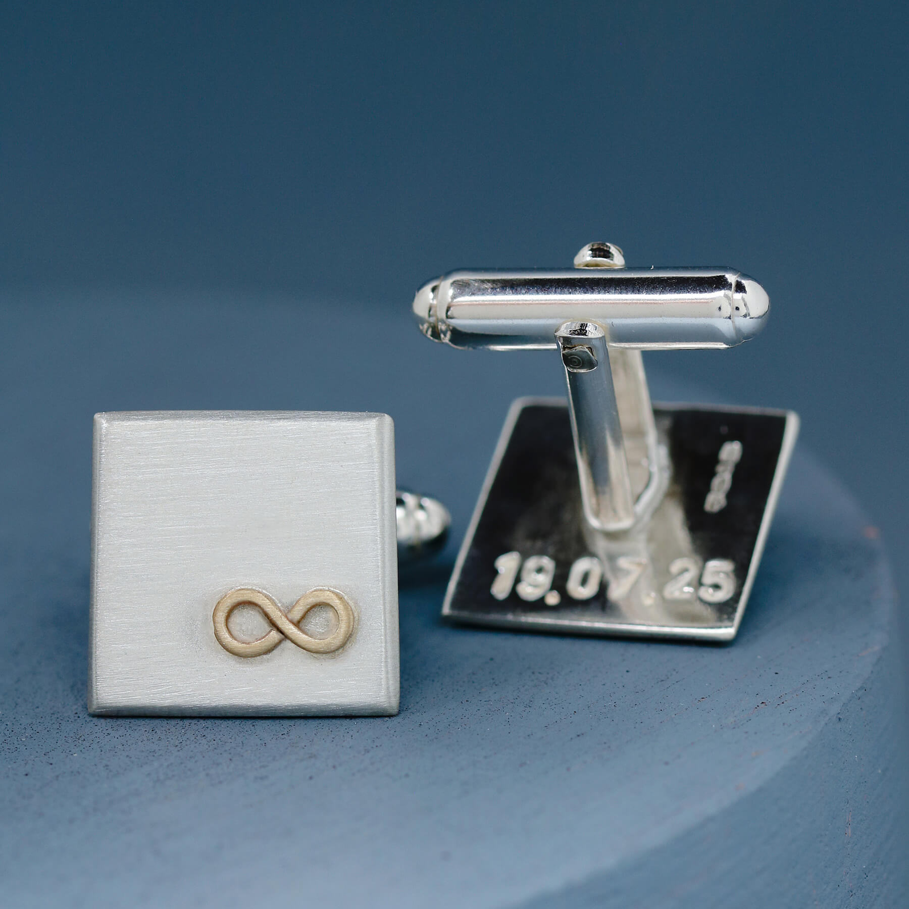 One cufflink face up to show the gold infinity symbol, the other upturned to reveal a hidden hand-stamped message on the reverse – a meaningful husband anniversary gift.