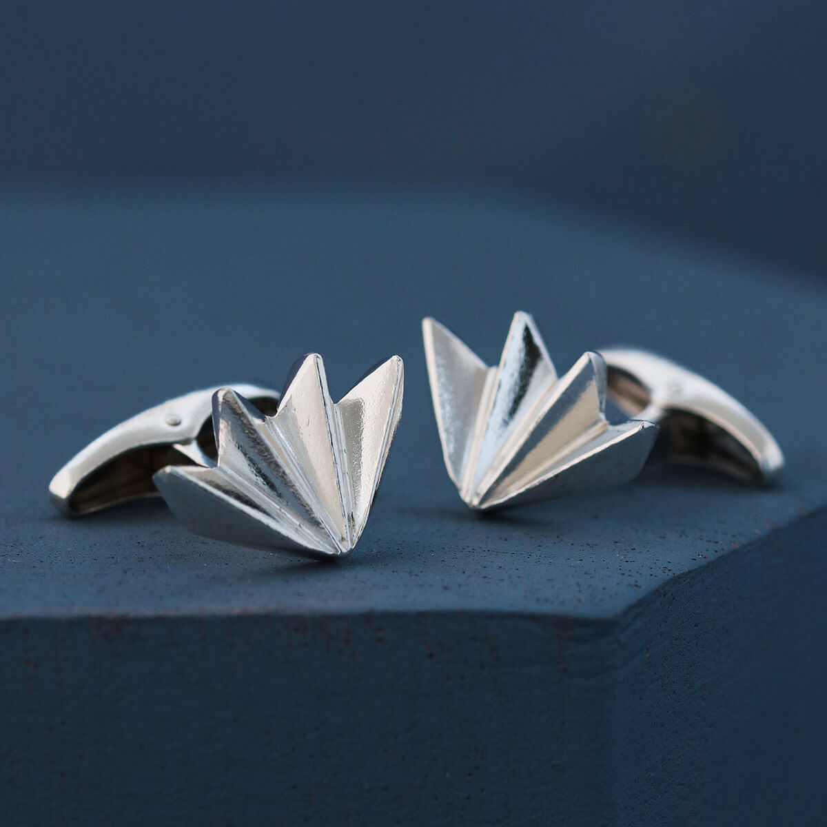 Close-up of men’s silver cufflinks on deep blue background showing detailed art deco fan pattern, perfect gift for husband or wedding day accessory