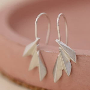 Sterling silver art deco drop earrings arranged on a soft pink dish; elegant fan drop earrings perfect for anniversaries and bridesmaid gifts.
