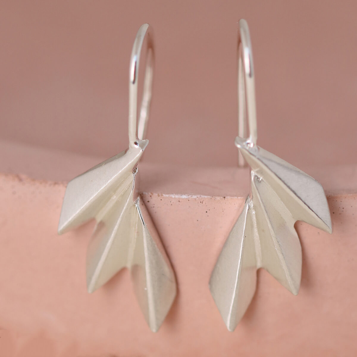 Art deco drop earrings displayed on a pink dish, showing the geometric fan design; ideal fan drop earrings gift for her or birthday jewellery.