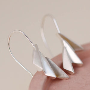 Close-up of fan drop earrings on a pink dish highlighting the ridged art deco detailing; great gift for Mum or milestone celebrations.