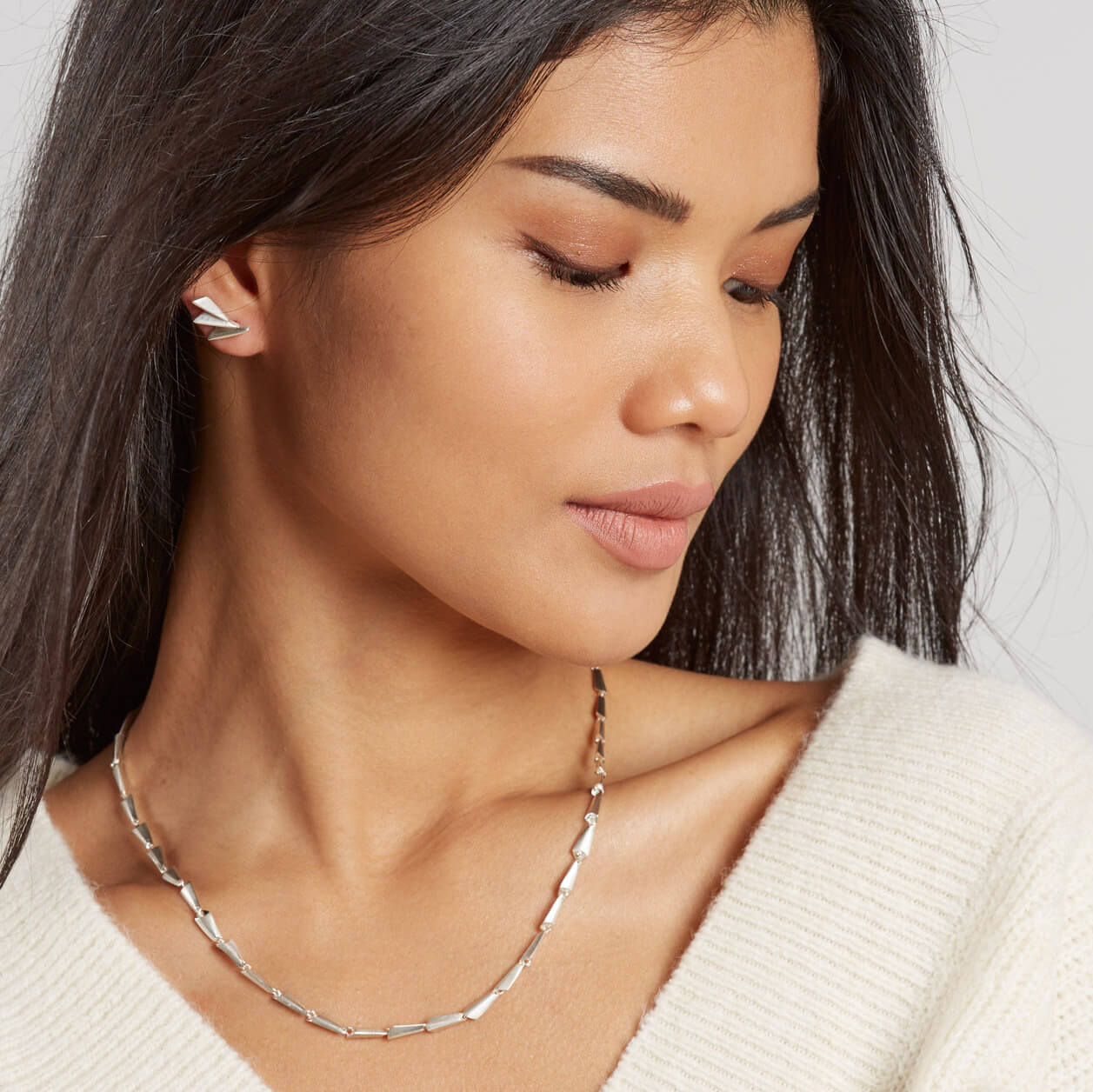 Model wearing art deco fan earrings styled for a minimal modern look.