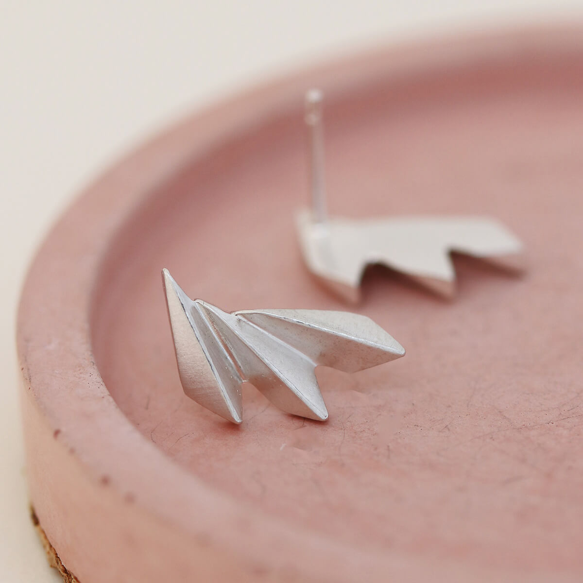 Sterling silver art deco silver earrings arranged neatly on a pink dish.