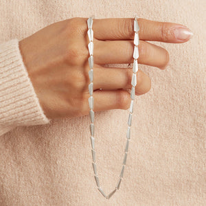 Sterling silver Art Deco link necklace draped over a model's hand, showing the sculptural links and movement of the necklace