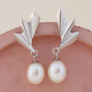 Art Deco pearl earrings laid flat to show the crisp silver ridges and 9mm teardrop pearl, elegant gift for mothers or bridesmaids.