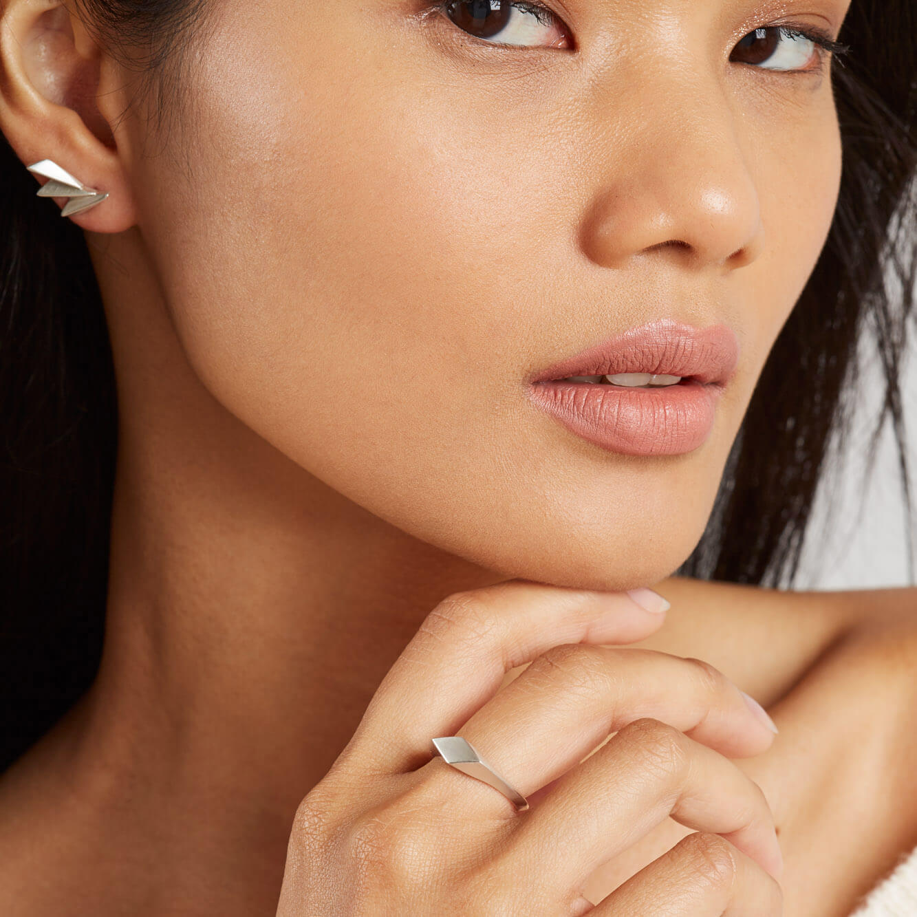 Art deco silver earrings worn with hair tucked back to highlight the fan shape.