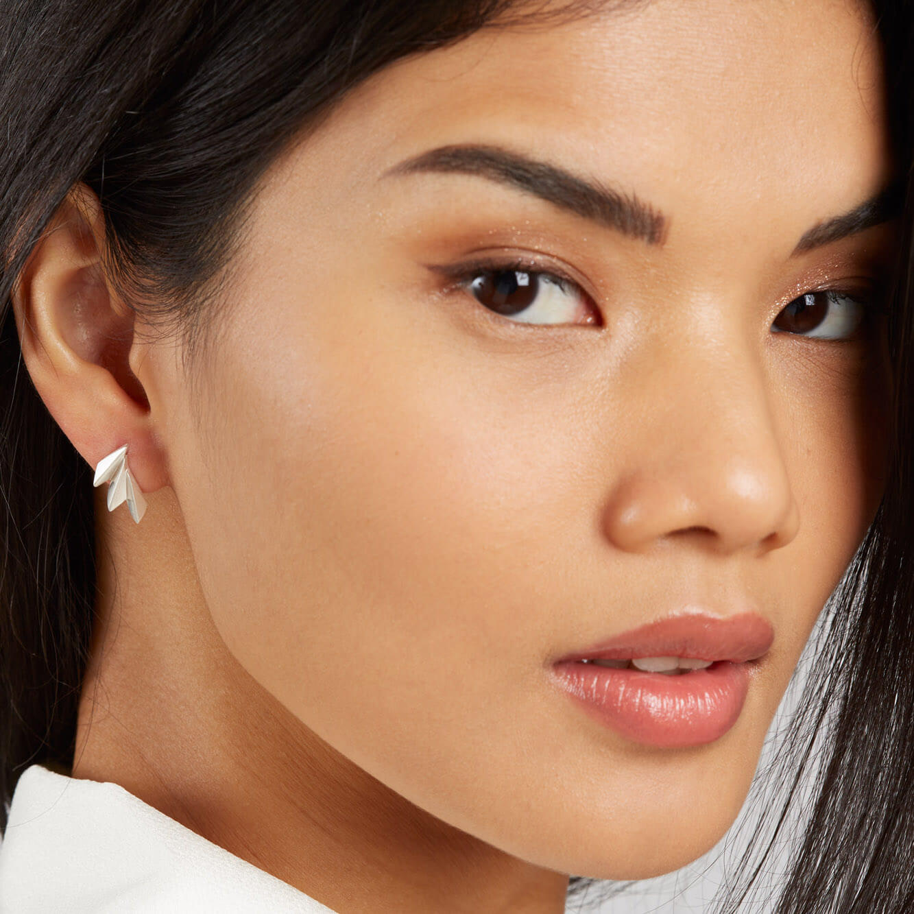 Art deco silver earrings shown worn on the ear to highlight everyday size and fit.