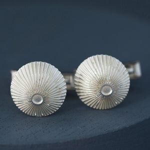 Sterling silver round cufflinks photographed flat on deep blue background – elegant silver cufflinks for Father’s Day or milestone birthday.