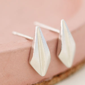 Detailed shot of art deco stud earrings resting on a pink dish, perfect for showcasing these art deco style earrings as a thoughtful gift for her.