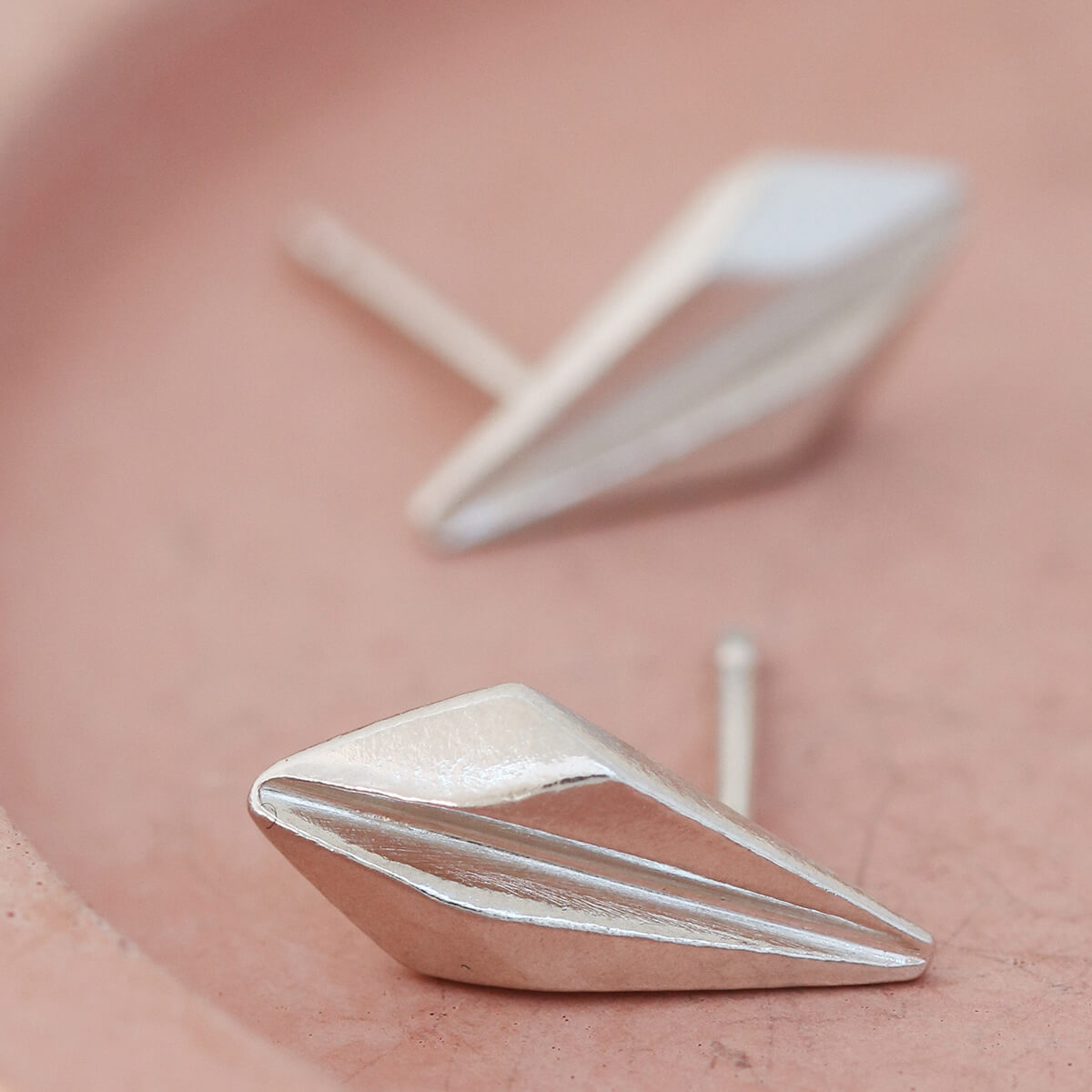 Sterling silver art deco stud earrings displayed on a pink dish, showcasing the geometric detailing of these art deco style earrings, ideal for gifting or weddings.