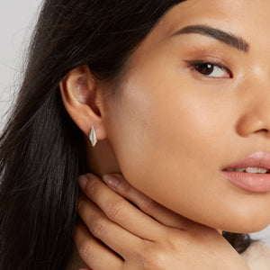 Model wearing sterling silver art deco stud earrings, showing the elegant geometric design of these art deco style earrings for everyday or bridal wear.