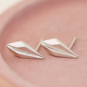Art deco style earrings in sterling silver displayed on a pink dish, showcasing their minimalist ridged detailing for timeless gifting occasions.