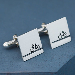 Handmade sterling silver bike cufflinks photographed on a deep blue background, ideal cycling gifts for him and thoughtful presents for dads or grooms.